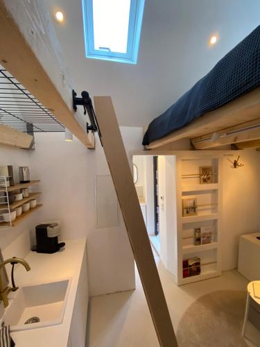 a room with white walls and a loft bed at Lüttje Huus Emden in Emden