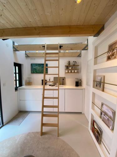 a kitchen with a ladder in the middle of a room at Lüttje Huus Emden in Emden