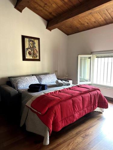 a bedroom with a large bed with a red blanket at Casa Petrucci 2 centro storico in Forlì