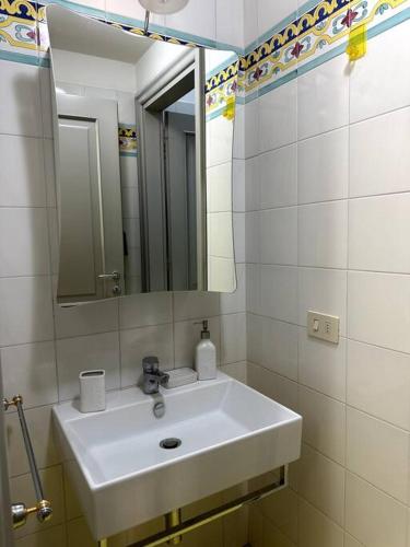 La salle de bains est pourvue d'un lavabo blanc et d'un miroir. dans l'établissement Casa Petrucci 2 centro storico, à Forlì