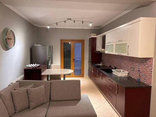 ein Wohnzimmer mit einem Sofa und einer Küche in der Unterkunft Choco apartment in Librazhd
