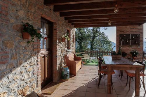 a patio with a table and chairs and a stone wall at la casina de Parres in San Juan de Parres
