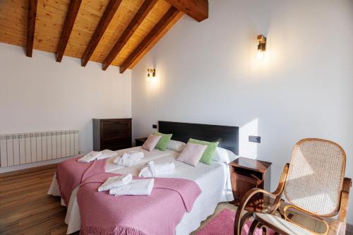 San Juan de Parresにあるla casina de Parresのベッドルーム1室(ピンクと緑の枕が備わるベッド2台付)