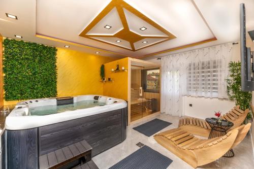 Lotus Wellness & spa apartman في كوبريفنيتسا: حمام كبير مع حوض استحمام ساخن وكراسي
