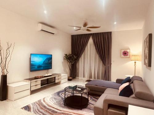 Quill Suites KLCC في كوالالمبور: غرفة معيشة مع أريكة وتلفزيون بشاشة مسطحة