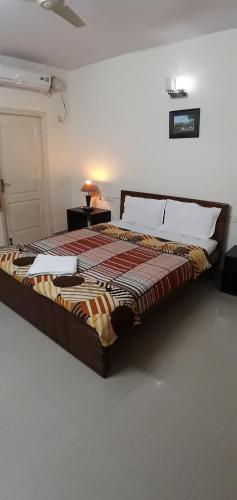 a bedroom with a bed and a table with a lamp at Service Apartment at Brookefield in Bangalore