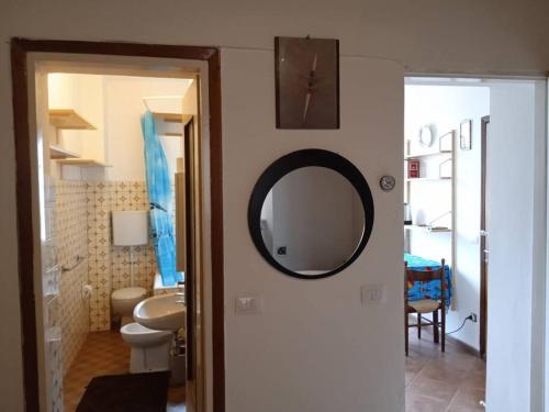 ein Bad mit einem Waschbecken und einem Wandspiegel in der Unterkunft Appartamento Prima Torre in Primaluna