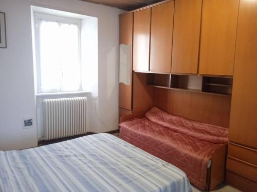 Kleines Zimmer mit einem Bett, Schränken und einem Fenster in der Unterkunft Appartamento Prima Torre in Primaluna