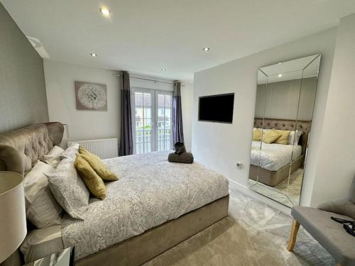 a bedroom with a large bed and a mirror at Bourton House Windrush Lake in South Cerney