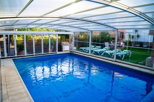 an indoor swimming pool with a retractable roof at Casa Rural El Nacimiento in Benaoján