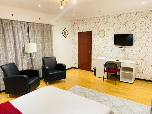 a room with chairs and a desk and a television at Airport Doozy Guest House in Kempton Park