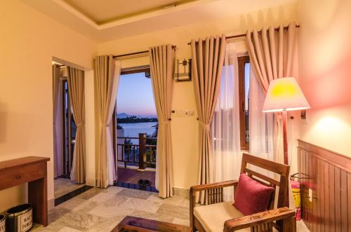 a living room with a view of the water at Villa Orchid Garden Riverside Hoi An in Hoi An