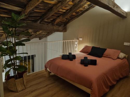 Un dormitorio con una cama con almohadas negras. en Alojamientos El lecho, en Treceño