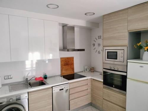 cocina blanca con fregadero y lavavajillas en Apartamento La Doncella, en Alcalá de Henares