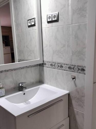 a bathroom with a white sink and a mirror at Apartamento La Doncella in Alcalá de Henares