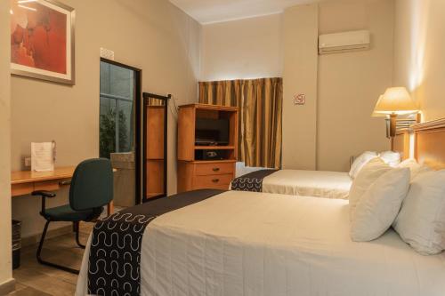 a hotel room with two beds and a desk at Hotel Boutique de Firma in Monterrey