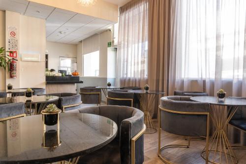 a restaurant with tables and chairs in a room at Hotel Boutique de Firma in Monterrey