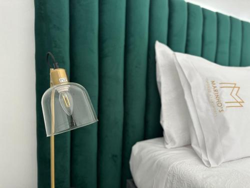 a lamp next to a bed with a green curtain at Marinho's Oporto Apartments in Porto