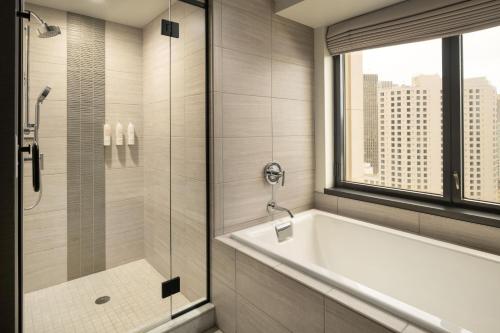 a bathroom with a tub and a shower with a window at San Francisco Marriott Marquis Union Square in San Francisco