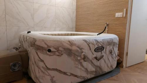ein Bad mit einer Marmorbadewanne in einem Zimmer in der Unterkunft F2 Paris 10ème Gare du nord - Stade de France - Parking in Saint-Denis