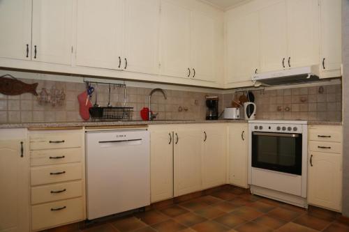 a kitchen with white cabinets and white appliances at Nordic character in Vidsel