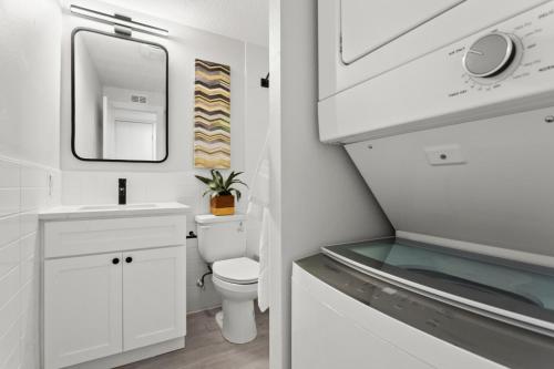 a bathroom with a toilet and a sink and a mirror at UNIVERSITY SERENITY SUITES in Tampa