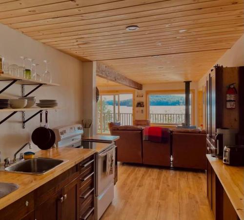 a kitchen with a sink and a stove top oven at Four Season Cottage with Wood Burning Sauna in Ompah
