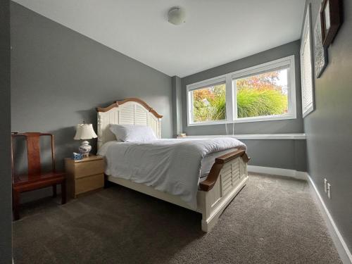 ein Schlafzimmer mit einem großen Bett und einem Fenster in der Unterkunft Galloping Goose B&B in Beautiful Victoria in Victoria