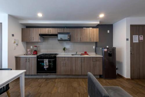 a kitchen with wooden cabinets and a stainless steel refrigerator at Departamento completo en el centro de CDMX in Mexico City