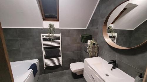 uma casa de banho com um lavatório, um espelho e um WC. em Men's World em Gyula