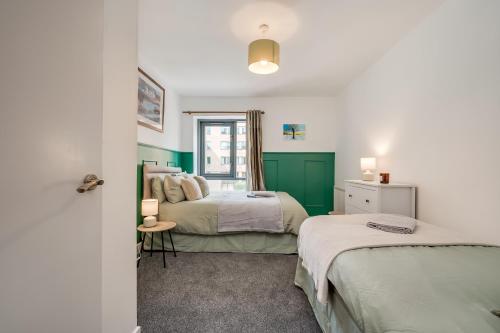 two beds in a room with green and white at Citygate Central Apartments in Belfast