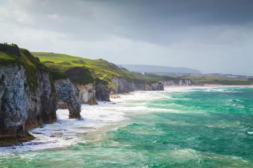 a painting of a beach with rocks and water at Citygate Central Apartments in Belfast