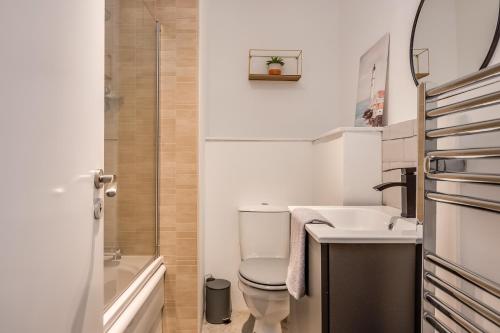 a small bathroom with a toilet and a sink at Citygate Central Apartments in Belfast