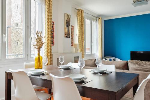 ein Esszimmer mit einem Holztisch und weißen Stühlen in der Unterkunft Appartement Voltaire - Welkeys in La Garenne-Colombes