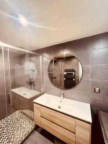 une salle de bain avec un lavabo et un miroir dans l'établissement Appartement Cosy au coeur de Paris, à Paris
