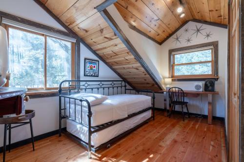um quarto com uma cama num quarto com tectos em madeira em Old World Charm em Angel Fire