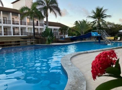 uma piscina com escorrega num resort em Apartamento Doce Lar Resort Treebies Subauma em Subaúma