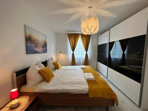 a bedroom with a large bed and a chandelier at Central Station Comfort, Your Cozy Home with free Parking in Salzburg