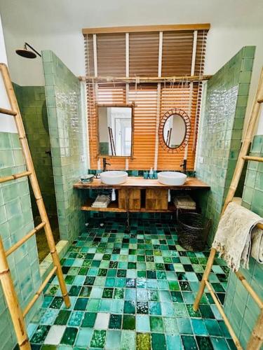 a bathroom with two sinks and a tiled floor at Casa Viva Begur in Begur