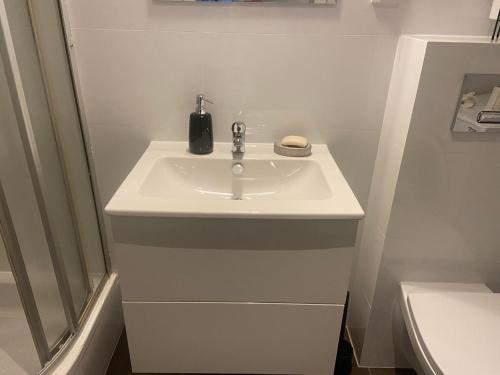 biała łazienka z umywalką i toaletą w obiekcie Pokoje pracownicze 2 sypialnie w Tomaszowie Mazowieckim