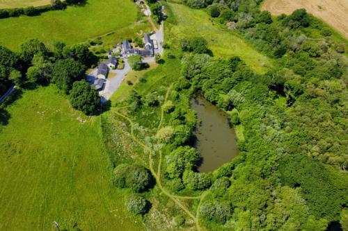 an aerial view of a farm with a pond at Meadowsweet Cottage Jacuzzi Edition in Saundersfoot