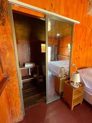 um quarto com uma porta que leva a uma cama e um espelho em Delta Chalé em Tutóia