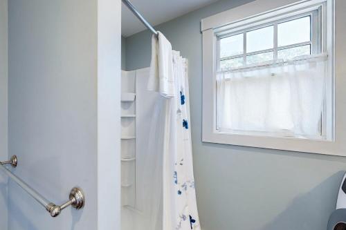 uma casa de banho com uma cortina de chuveiro e uma janela em The Mermaid Suite em Vineyard Haven