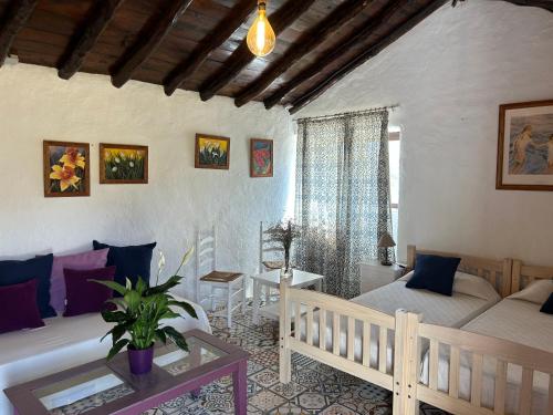 uma sala de estar com duas camas e uma mesa em Casa Granada em Estepona
