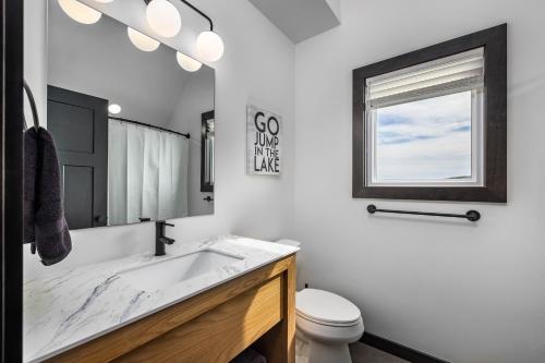ein Badezimmer mit Waschbecken, Toilette und Spiegel in der Unterkunft NEW! Luxury Lakefront Lodge 1- FREE Pool/Hot Tub, Pickleball, Mini Golf and More! in Kimberling City