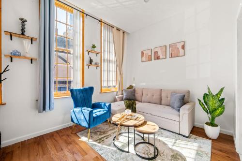 a living room with a couch and blue chairs at Charming Home In Heart of City With King Size Bed! in Philadelphia