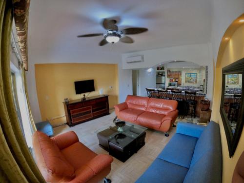 a living room with orange and blue furniture and a tv at Oceanview Condo Vela Vallarta condo in Puerto Vallarta