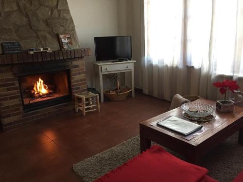 sala de estar con chimenea y TV en Al Viento, Alojamiento & Turismo Rural Prádena del Rincón, en Prádena del Rincón