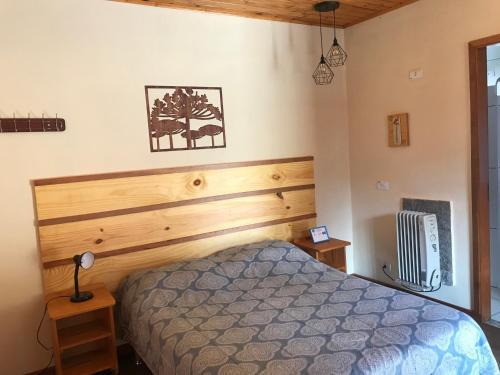 1 dormitorio con 1 cama con cabecero de madera en Chalés Toca dos Esquilos, en Campos do Jordão