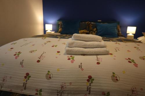 ein Bett mit drei Handtüchern und Blumen drauf in der Unterkunft The Evergreen Inn in Banbury